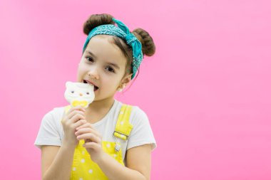 Lolipopunu ısıran küçük kızın görüntüsü.