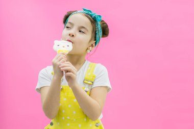 Puantiyeli kız elinde lolipop tutuyor..