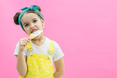 Lolipopu olan güzel bir kız. Pembe arkaplan