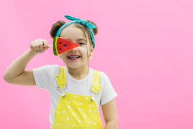 Küçük model gözünü karpuz lolipopun arkasına gizliyor..