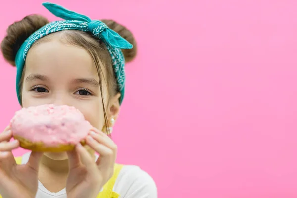Little girl has a donut in her hands. — Stock Photo, Image
