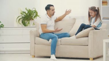 4k video 'da üzgün küçük kız kanepede oturuyor, kızgın ebeveyn kavgası, ailevi sorunlar.