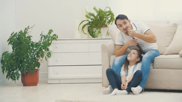 4k video, kde si otec hraje s culíky své dcery, pózuje před kamerou. — Stock video