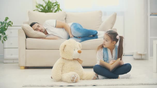 4k-Video, in dem Mädchen ihrem Teddybär ein Buch vorliest. — Stockvideo