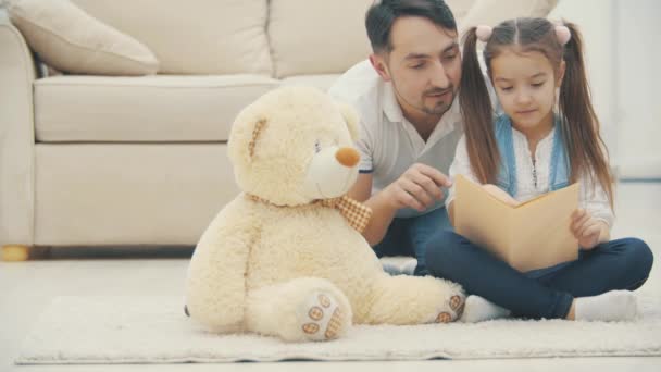 4kビデオここで父は彼の小さな娘に読むことを教える. — ストック動画
