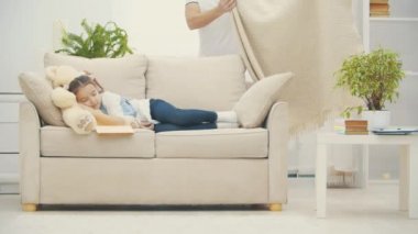 4k video, babasının küçük kızını bir battaniyeyle kanepede örttüğü.