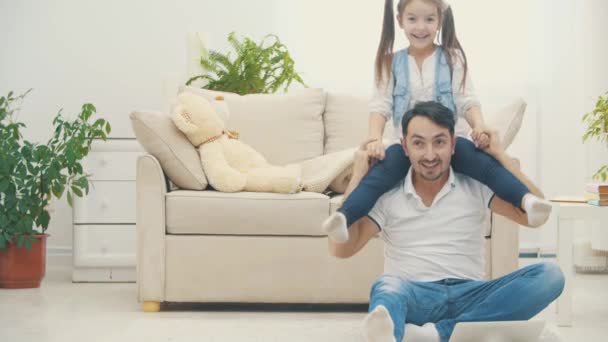 Padre sostiene a su preciosa hijita sobre sus hombros y luego cayeron al suelo en video de 4k. — Vídeo de stock
