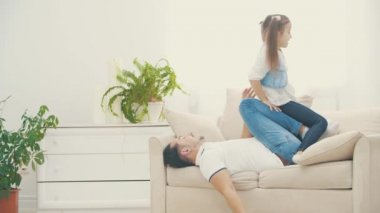 4K yavaş çekim videosu, babasının küçük kızıyla oynadıktan sonra beyaz koltukta oturduğu bölüm..