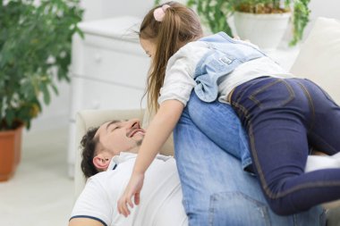 Mutlu aile oturma odasında beyaz koltukta..