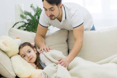 Babası ona bakarken küçük kız uyuyor.,