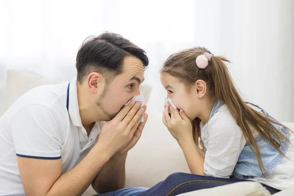 Kız ve baba mendille burunlarını siliyorlar..