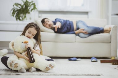 Sarhoş baba beyaz kanepeye uzanmış birasını geri istiyor..