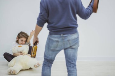 Elinde bira şişesi olan bağımlı bir adam kızını tehdit ediyor, taciz ediyor ve aşağılıyor..