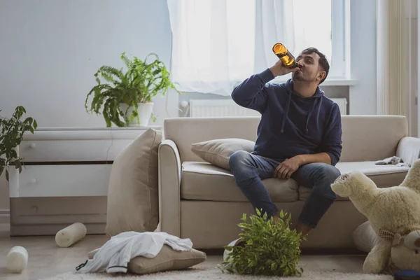 Snygg deprimerad man dricker alkohol hemma. — Stockfoto
