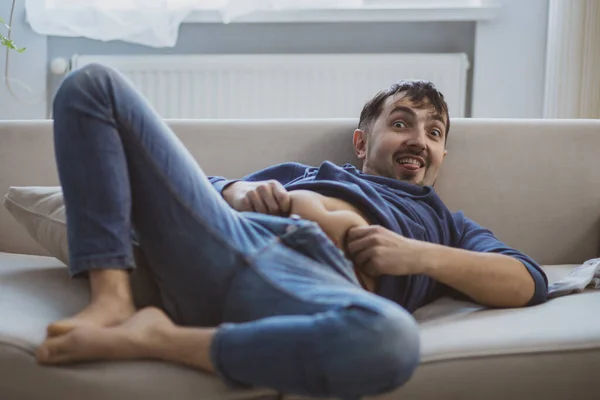 En man som lider av baksmälla och ligger på soffan. — Stockfoto