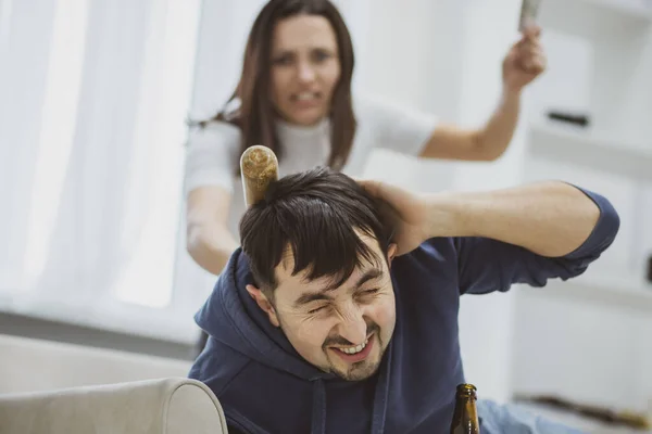 Uma esposa bate no marido por estar bêbada usando um taco . — Fotografia de Stock