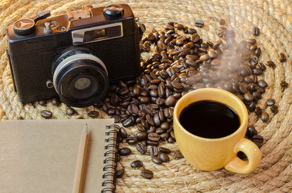 Taza de café con un viejo portátil de cámara en una cuerda de yute . — Foto de Stock