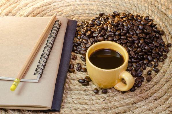 Tasse Kaffee mit Notizbuch auf einem Jute-Seil. — Stockfoto