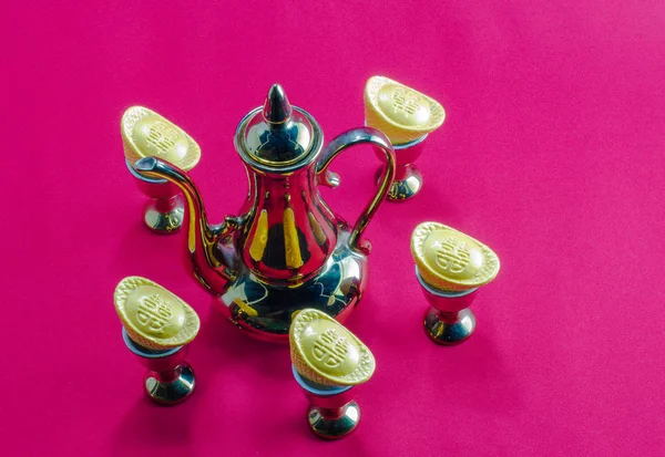 Ouro lingote jarro de ouro vidro de chá no fundo vermelho . — Fotografia de Stock