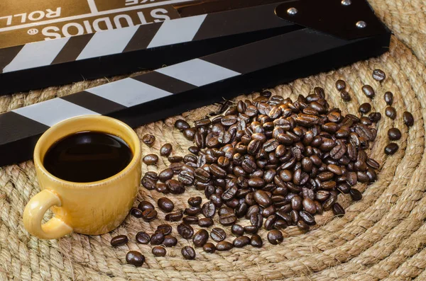 Taza de café caliente con granos de café pizarra en una cuerda de yute . —  Fotos de Stock