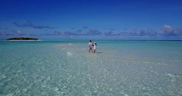v03913 Aerial flying drone view of Maldives white sandy beach 2 people young couple man woman romantic love on sunny tropical paradise island with aqua blue sky sea water ocean 4k