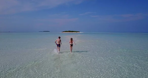 v03964 Aerial flying drone view of Maldives white sandy beach 2 people young couple man woman romantic love on sunny tropical paradise island with aqua blue sky sea water ocean 4k
