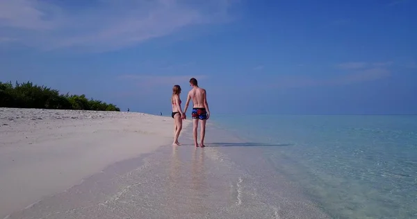 v03963 Aerial flying drone view of Maldives white sandy beach 2 people young couple man woman romantic love on sunny tropical paradise island with aqua blue sky sea water ocean 4k