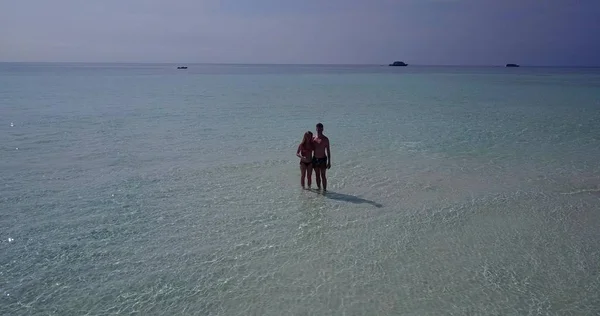 v04028 Aerial flying drone view of Maldives white sandy beach 2 people young couple man woman romantic love on sunny tropical paradise island with aqua blue sky sea water ocean 4k