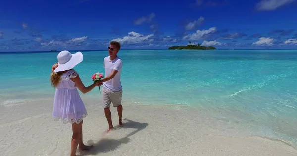 v07469 Maldives white sandy beach 2 people a young couple man woman standing together in love on sunny tropical paradise island with aqua blue sky sea water ocean 4k