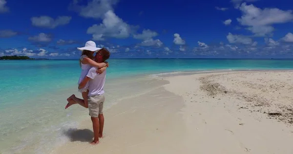 v07474 Maldives white sandy beach 2 people a young couple man woman standing together in love on sunny tropical paradise island with aqua blue sky sea water ocean 4k