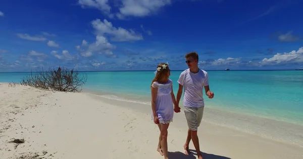 v07517 Maldives white sandy beach 2 people a young couple man woman walking together in love on sunny tropical paradise island with aqua blue sky sea water ocean 4k