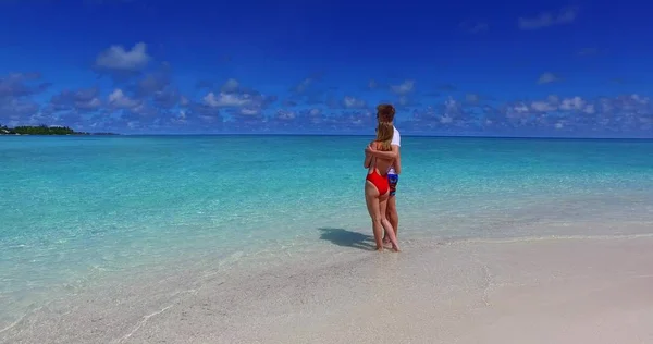 v07536 Maldives white sandy beach 2 people a young couple man woman walking together in love on sunny tropical paradise island with aqua blue sky sea water ocean 4k