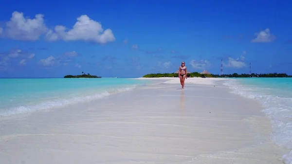P02035 Aerial flying drone view of Maldives white sandy beach happy 1 person young beautiful young woman walking on sunny tropical paradise island with aqua blue sky sea water ocean 4k