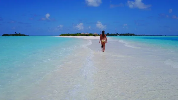 P02061 Aerial flying drone view of Maldives white sandy beach happy 1 person young beautiful young woman walking on sunny tropical paradise island with aqua blue sky sea water ocean 4k