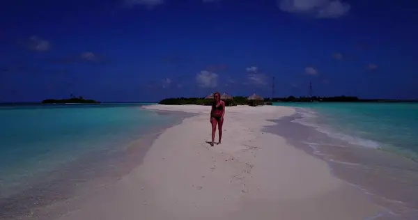 v13777 one beautiful young girl in bikini sunbathing and walking by the aqua blue sea water on white sand in the sun