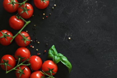 Siyah arka planda baharatlı taze domatesler. Üst görünüm