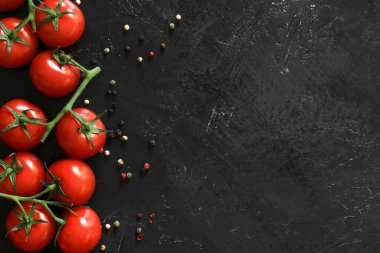Siyah arka planda baharatlı taze domatesler. Üst görünüm