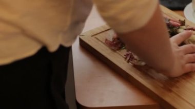 Domates ahşap kesme tahtası üzerinde kesme erkek eller