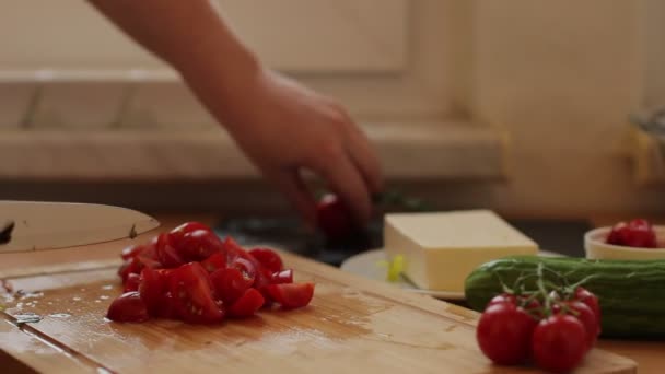 Mãos femininas cortando tomate na tábua de corte de madeira — Vídeo de Stock