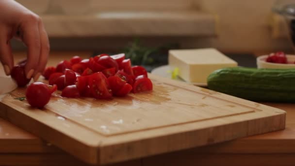 Mains féminines coupant la tomate sur la planche à découper en bois — Video