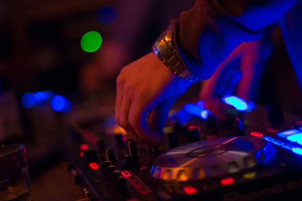 DJ turntable console mixer controlling with two hand in concert nightclub stage. Royalty Free Stock Images