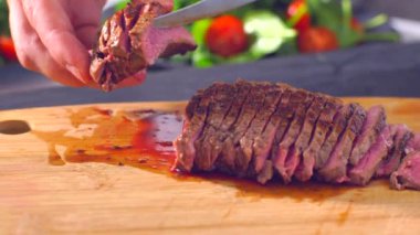 Ahşap tahtada et kesen şef.