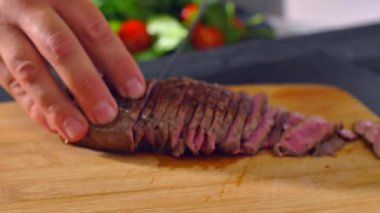 Ahşap tahtada et kesen şef.