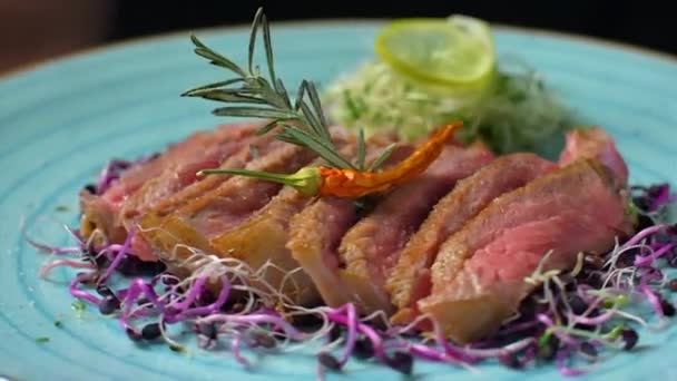 Chef pfeffert fertige Steaks auf einem Teller — Stockvideo