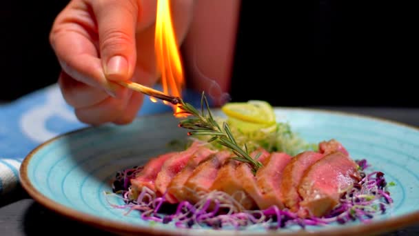 Closeup view of raw uncooked slice of meat and fresh vegetables with flames. bbq burn original mexico recipe dish black plate chilli pepper professional cooking exotic meal cook recipe preparing food — Stock Video