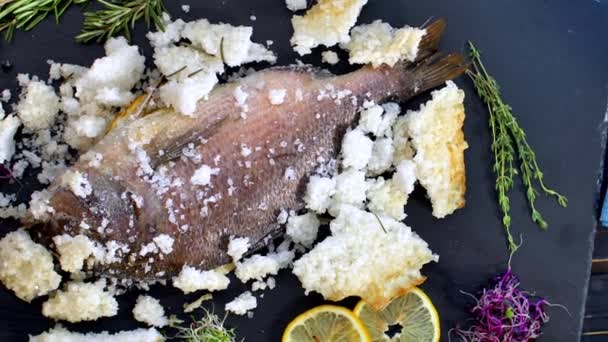 O cozinheiro limpa o peixe cozido no forno no sal . — Vídeo de Stock