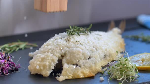 The cook cleans the baked fish in salt. — Stock Video