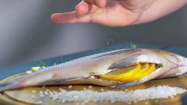 Zeebrasem vis, versierd met groene takken en tomaten — Stockvideo