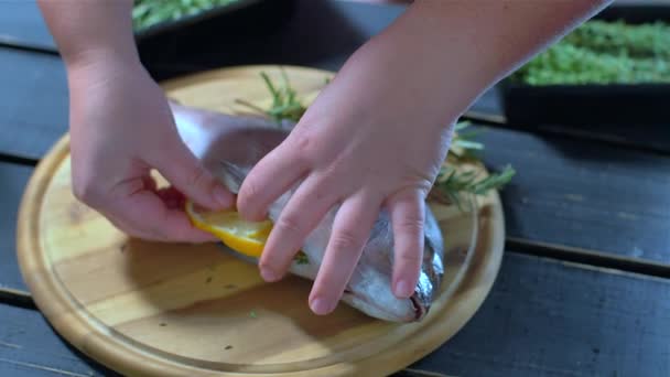 Sea bream fish, decorated with green branches and tomatoes — Stock Video