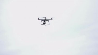 Mavi gökyüzü arka planında siluet içinde uçan drone, mavi arka planda mavi ışık, yavaş çekim